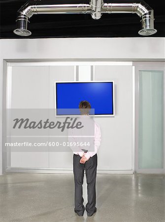 Businessman Looking at Big Screen Television