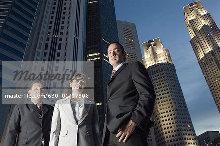 Porträt von zwei Geschäftsmänner stehend mit einer geschäftsfrau mit Wolkenkratzern im Hintergrund, Singapur
