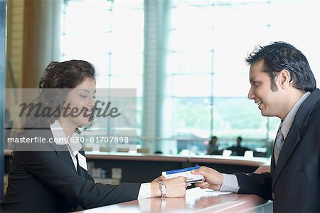 Homme d'affaires avec une compagnie aérienne archiver préposé à un aéroport check-compteur