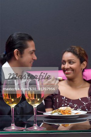 Mid adult man feeding a young woman in a restaurant