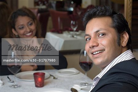 Young couple sitting in a restaurant and smiling