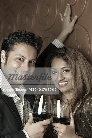 Portrait d'un jeune couple tenant des verres de vin