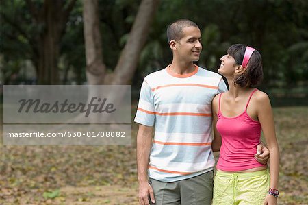 Young couple walking in a park and looking at each other