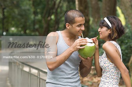 Junges Paar Kokosmilch trinken und Lächeln