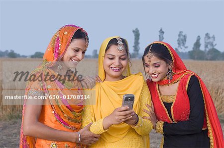 Three young women looking at a mobile phone