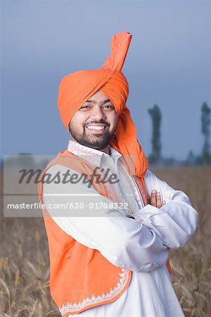 Porträt eines jungen Mannes in ein Weizenfeld stehen und Lächeln