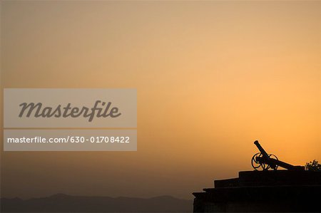 Silhouette of a cannon at sunset, Neemrana Fort, Neemrana, Alwar, Rajasthan, India