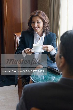 Rückansicht eines Kaufmanns sitzend vor eine geschäftsfrau und eine Tasse Tee
