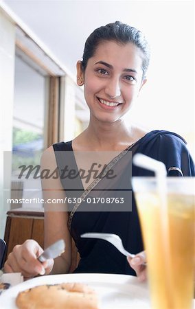 Portrait d'une jeune femme de manger de la nourriture dans un restaurant