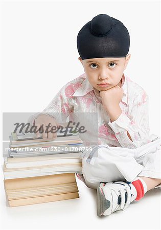 Portrait of a boy sitting with books