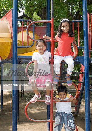 Portrait of a boy playing with two girls on the jungle gym