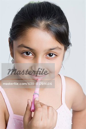 Portrait of a girl applying lipstick