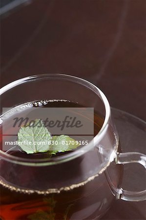 Gros plan d'une tasse de tisane avec des feuilles de menthe dans une tasse