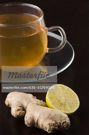 Close-up of a cup of herbal tea with a ginger and a lemon slice