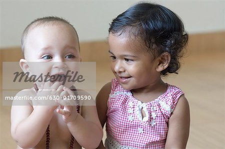 Close-up of a baby boy and a girl smiling