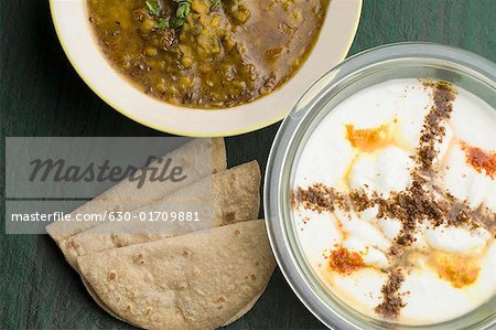 Close-up of three chapattis with chickpea curry and rayta