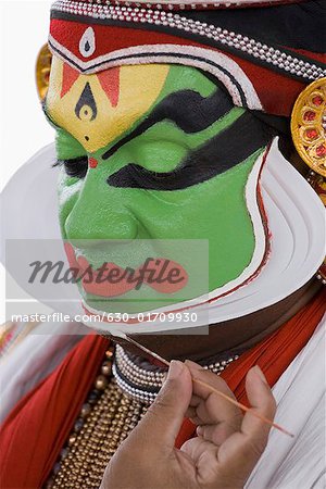 Nahaufnahme einer Kathakali Tanz Performer Make-up im Gesicht anwenden
