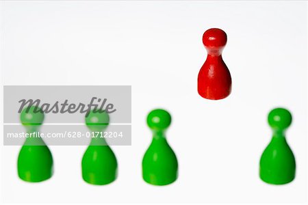 Red game piece standing beside green ones