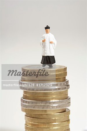 Priest figurine on a stack of coins