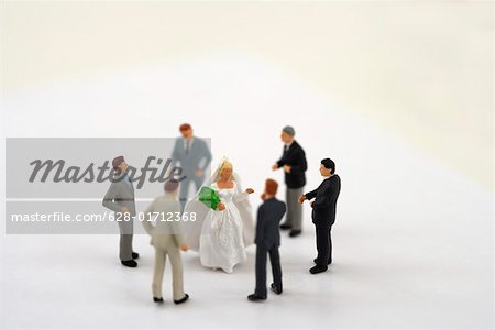 Bride figurine surrounded by businessmen figurines