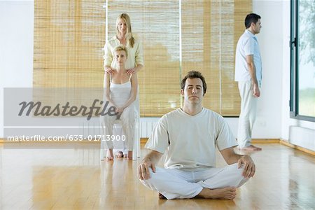 Four adults in various postures in wellness center