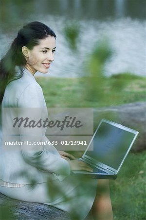 Femme à l'aide de laZSop dans le parc, lac en arrière-plan