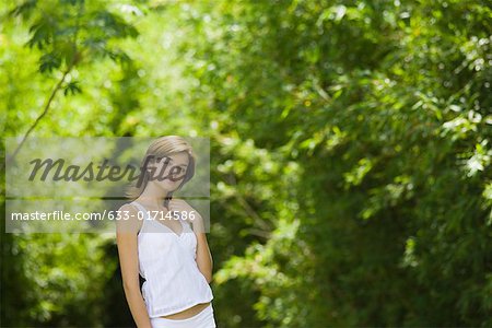 Jeune femme debout en bois avec la main dans les cheveux, à la recherche de suite