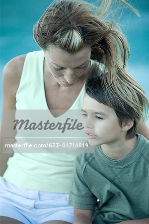 Boy and mother sitting in wind, portrait