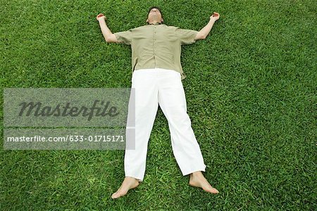 Man lying on grass, full length