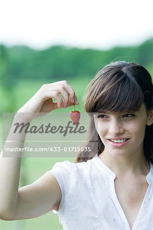 Junge Frau hält Erdbeere