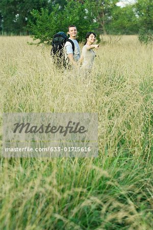 Young couple going for hike, woman pointing out of frame