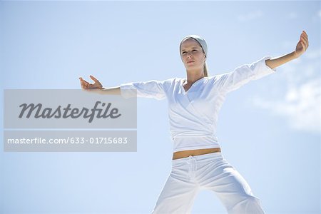 Young woman doing relaxation exercises, low angle view