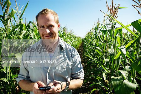 Landwirt im Maisfeld mit elektronischer Organizer