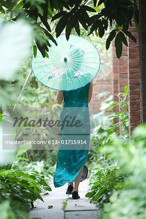 Junge Frau, gekleidet in traditioneller chinesischer Kleidung gehen mit Sonnenschirm, Rückansicht