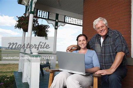 Father and Daughter with Laptop on Porch of Farmhouse