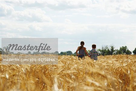 Brother and Sister Running through Grain Field