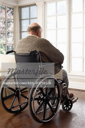 Senior homme en fauteuil roulant, fenêtre