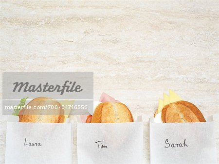 Trois sandwichs dans des sacs en papier