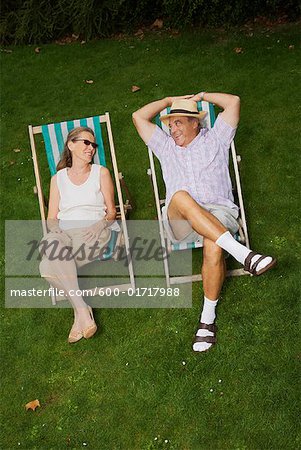 Couple assis dans des chaises de jardin