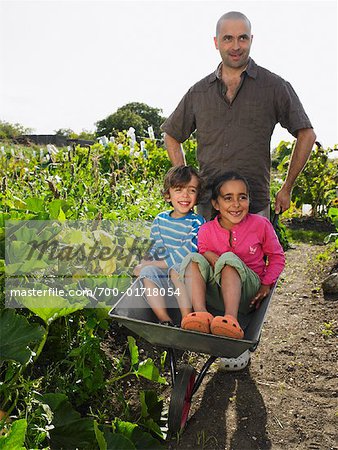 Homme poussant les enfants dans la brouette