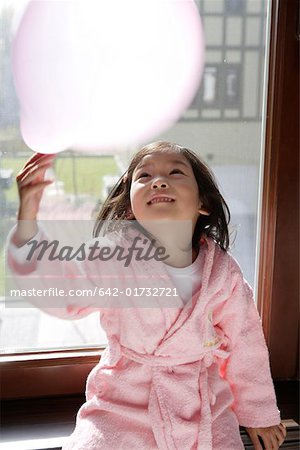 Fille jouant avec un ballon, souriant, en levant