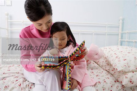 Mother reading out bedtime story to her daughter