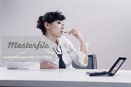 Young woman making up with lip coat