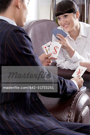 Young man and young woman playing card with smile