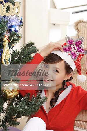 Portrait de jeune femme assise de l'arbre de Noël, souriant