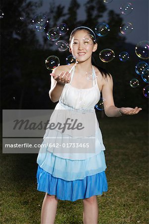 Young woman playing with bubbles