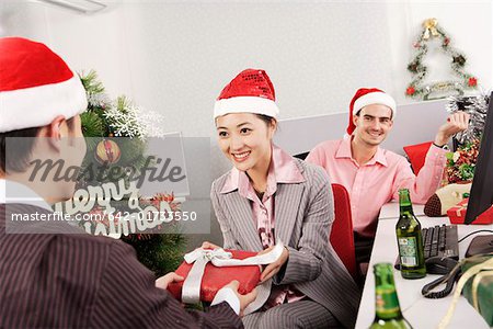 Office woman giving gift to man on Christmas Day
