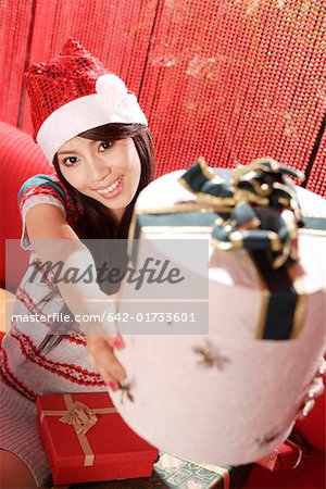 Young woman lifting a Christmas gift box