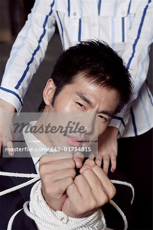 Portrait of a businesswoman hands tied with a rope