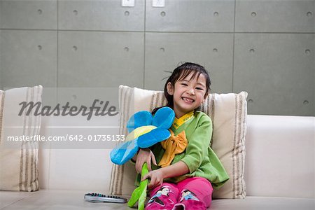 Portrait of girl playing with flower toy